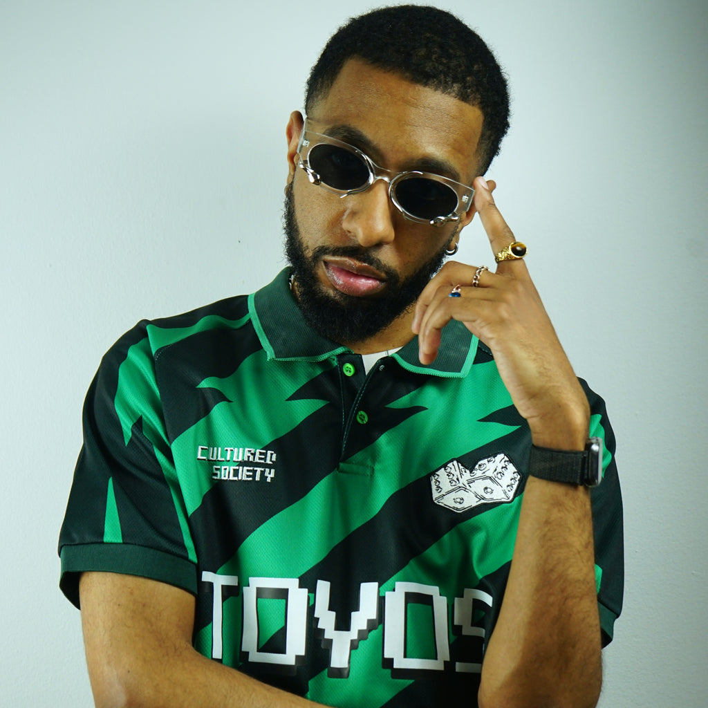 Person wearing a green and black sports jersey with visible branding