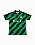 Green and black striped polo shirt with 'TOYOS' branding on a white background
